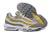 Side view of grey, white and yellow Nike Air Max 95 TT sneakers showing the sole and tread.