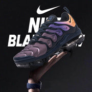 Angled view of a Nike Air VaporMax Plus sneaker against a dark background.