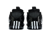 Rear view of the black sneakers showing white and black vertical outsole accents.