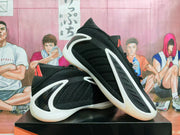 Angled view of black sneakers showing the textured upper, white overlays, and red accents