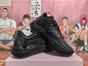 Black sneakers arranged at an angle to show the side panels, laces, and patterned outsole.
