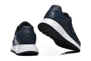Rear and outsole views of navy sneakers with white midsoles and black tread.