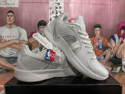 Angled view of the white Nike sneakers displaying the side panels, gray Swoosh detailing, sculpted midsoles, and outsoles.