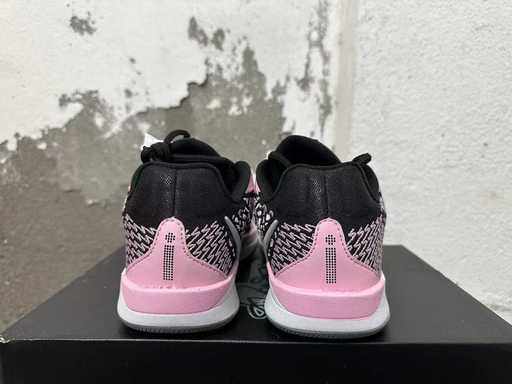 Rear view of pink and black low-top basketball shoes showing patterned heel panels and pink heel accents.