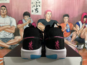 Rear view of black Nike GT Cut 3 shoes with pink details and blue outsole accents