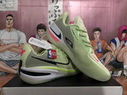 Angled view of the light green Nike basketball sneakers showing the mesh upper, black Swoosh, pink accents, and translucent outsole.