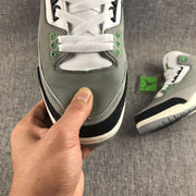 Close-up of the gray toe box, white laces, green eyelets, and black textured toe overlay.