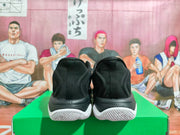 Rear view of black Nike basketball shoes with white outsole accents.