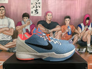Side view highlighting the black Swoosh, blue upper, light-colored heel and midsole, and translucent outsole.