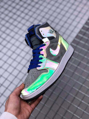 Angled close-up showing the reflective green and pink-purple panels, gray toe area and blue laces.