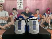 Rear view of white and blue Nike sneakers showing blue heel accents, horizontal heel details, and speckled midsoles.
