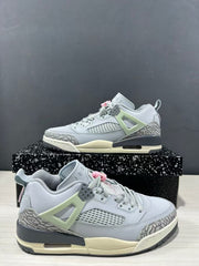 Close angled view of the Jordan Spizike Low sneakers showing the mesh side panel, elephant-print overlays, grey laces, and pink accents.