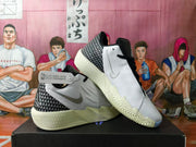Angled view showing the white upper, patterned heel, black trim, and textured outsole