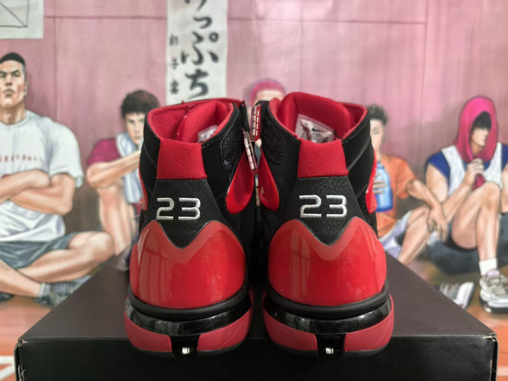 Rear view of black and red high-top sneakers showing the red heel panels, black midsoles, and number 23 details.