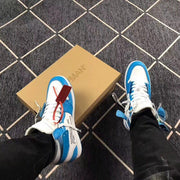 Top-down view of the pair worn with blue and white uppers, white laces, and red and blue accessory tags.