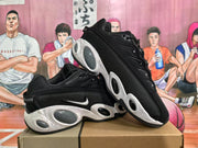 Angled view of two black Nike sneakers showing the side swooshes, speckled midsoles, and rounded cushioning elements.