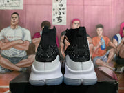Rear view of the white and black high-top basketball shoes, showing heel details and translucent-looking outsole.