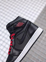 Close side view highlighting the black upper, side logo, red laces, and red collar emblem.