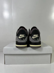 Rear view showing Nike Air branding, gray heel overlays, black heel panels, and cream midsole accents.