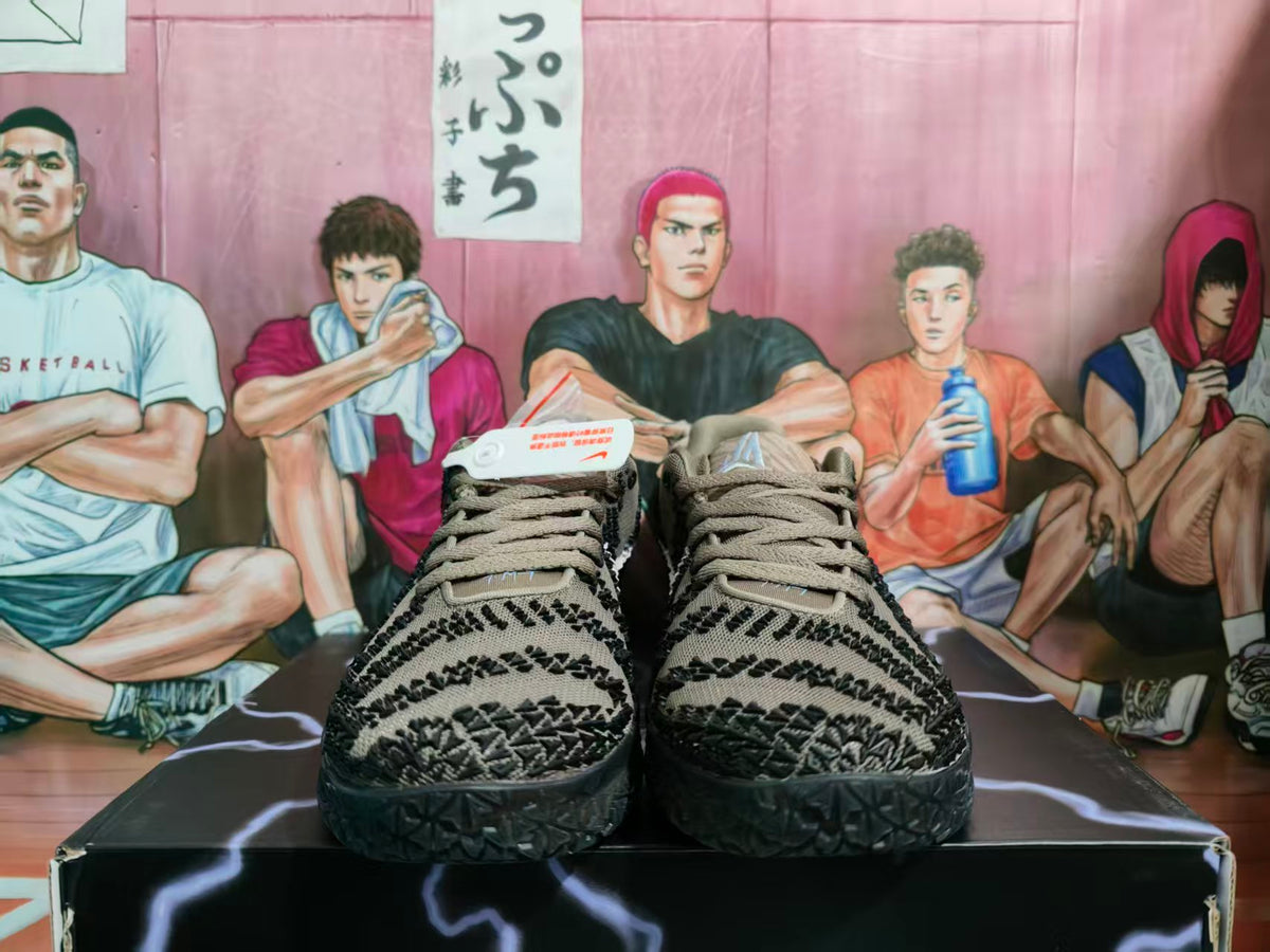 Front view of brown and black Nike basketball sneakers with pale pink accents on a graphic shoe box.