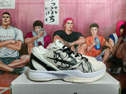 Side profile of a white and black Nike basketball sneaker with brush-style graphic artwork, textured upper, and layered sole.