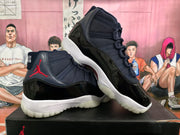 Two black and dark blue high-top sneakers arranged on a box, showing red branding, white midsoles, and translucent outsoles.