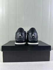 Rear view of black and white Jordan Legacy 312 sneakers displayed on a black shoebox.