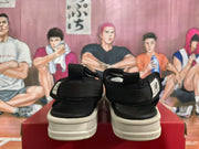 Rear view of a pair of black New Balance sandals showing the heel straps, pull tabs, and open footbeds.