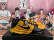 Side view showing the yellow and black sneaker upper, contrasting swoosh, yellow laces, and black outsole.