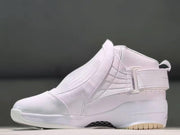 Angled side view showing the strap, textured panels, and toe panel of the white sneaker.