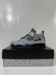 Single gray Air Jordan 4 Retro sneaker displayed in profile on a black shoebox.