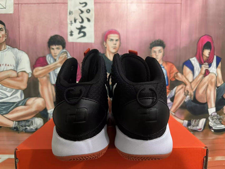 Rear view of black basketball sneakers with white midsoles and gum outsoles