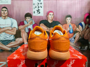 Rear view showing the orange heel panels with NIKE branding and ribbed midsoles.
