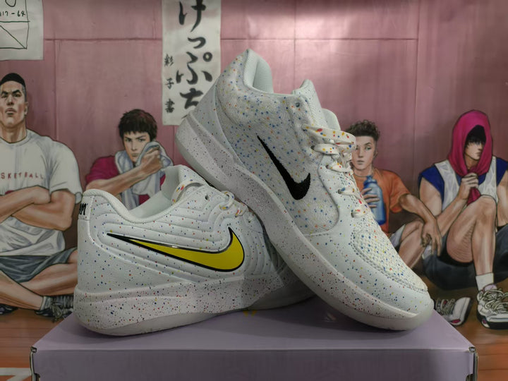 Pair of white multicolor-speckled basketball-style sneakers displayed on a box, showing contrasting side markings and padded collars.