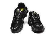 Front and top views of black Nike Shox TL sneakers with white lace details.