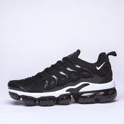 Side profile of a black and white Nike TN-10 sneaker.
