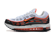 Side profile of white Nike sneakers with black and bright orange layered panels.