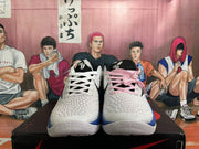 Front view showing the textured white uppers, black tongues, and contrasting pink and white laces.