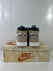 Rear view of brown, black, and white high-top sneakers displayed on a branded shoe box.