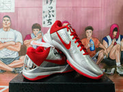 Angled view of the silver and red basketball sneakers with perforated panels and metallic heel details.