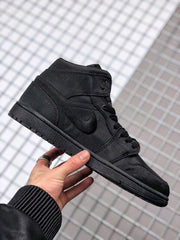 Angled side view of the black high-top sneaker with tonal overlays and rubber outsole.