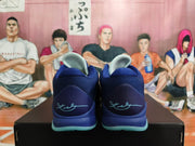 Rear view of deep blue basketball shoes with aqua outsole accents and a signature on the heels