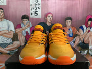 Front view of orange basketball sneakers with orange laces, black detailing, and white-and-orange soles.