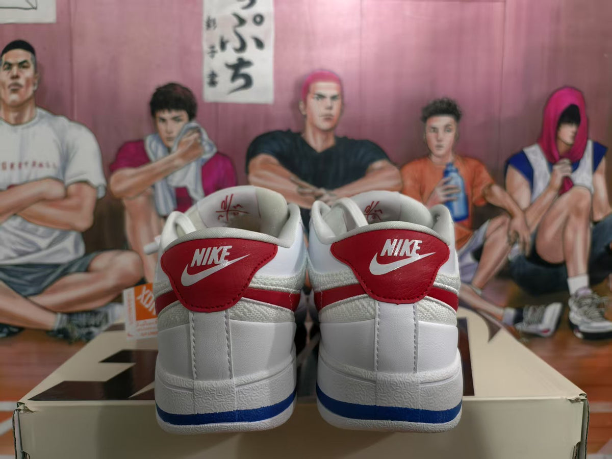 Rear view of white Nike low-top sneakers with red heel panels, blue outsole accents, and visible Nike branding.