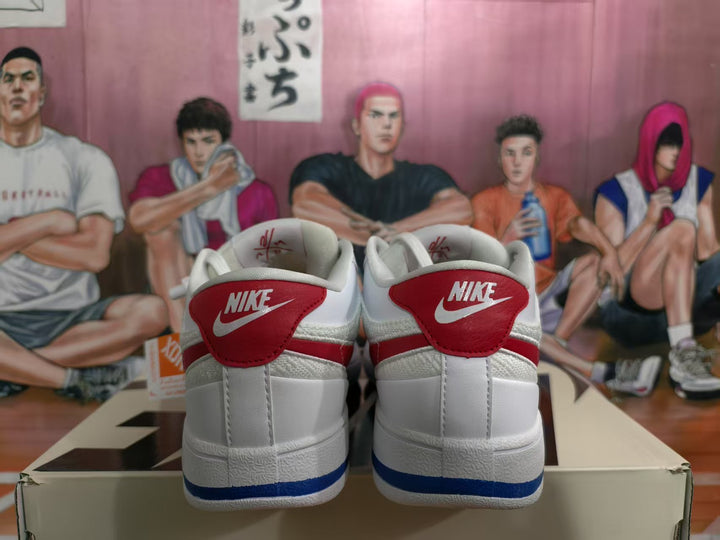 Rear view of white Nike low-top sneakers with red heel panels, blue outsole accents, and visible Nike branding.
