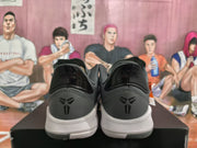 Rear view showing padded collars, heel panels and basketball-style emblems on the dark gray sneakers.