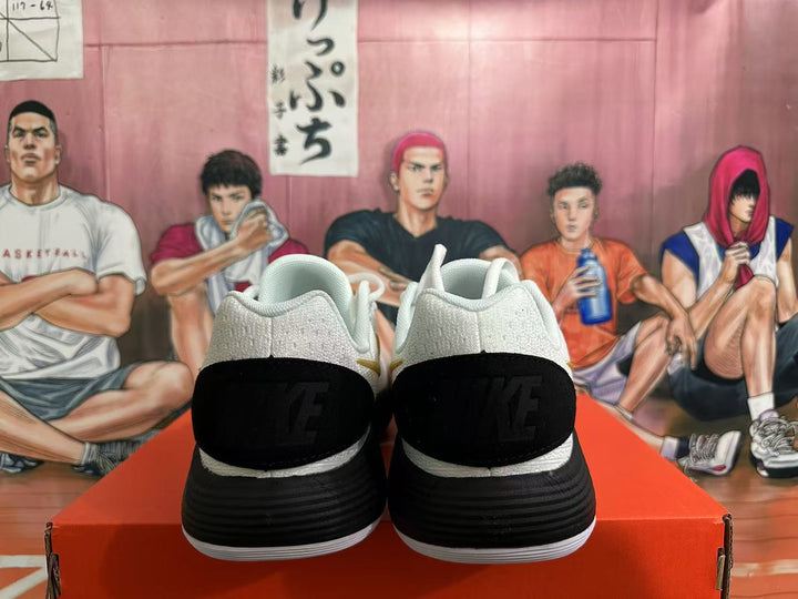 Rear view of white Nike basketball shoes with black heel panels and black-and-white soles