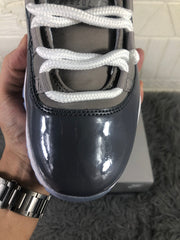 Close-up of the glossy dark toe panel, white laces, and grey upper.