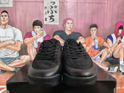 Front view of the black sneakers showing the lace-up closure, perforated toe panels and thick rubber outsoles.