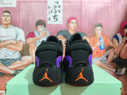 Rear view of black Jordan sneakers with orange heel logos